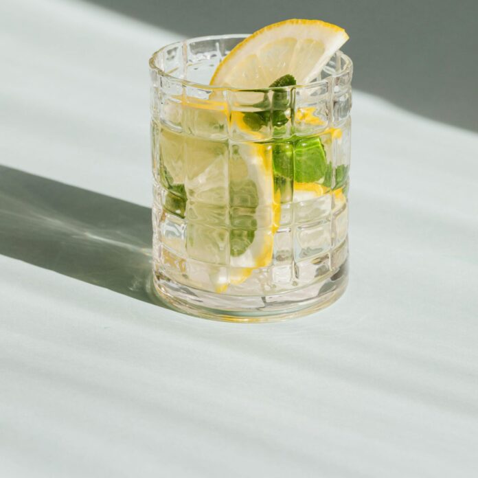 Glass of fresh drink on white background