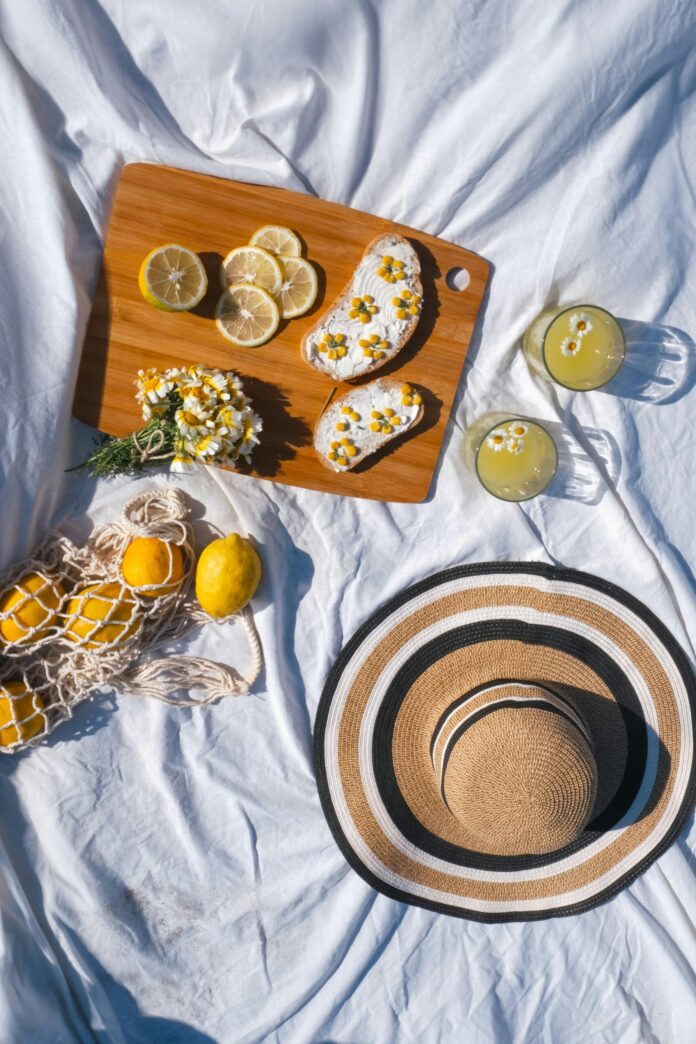 Food, Drinks and a Sunhat on a Blanket in Sunlight