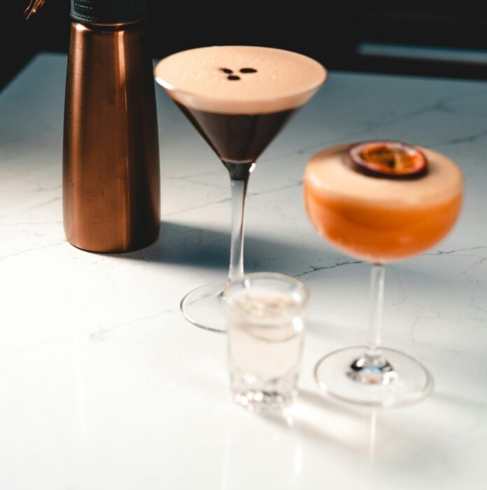 Espresso martini next to a NitroPress machine and another cocktail