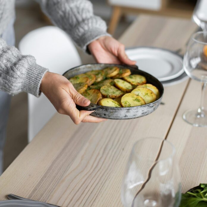Crop woman serving table for dinner